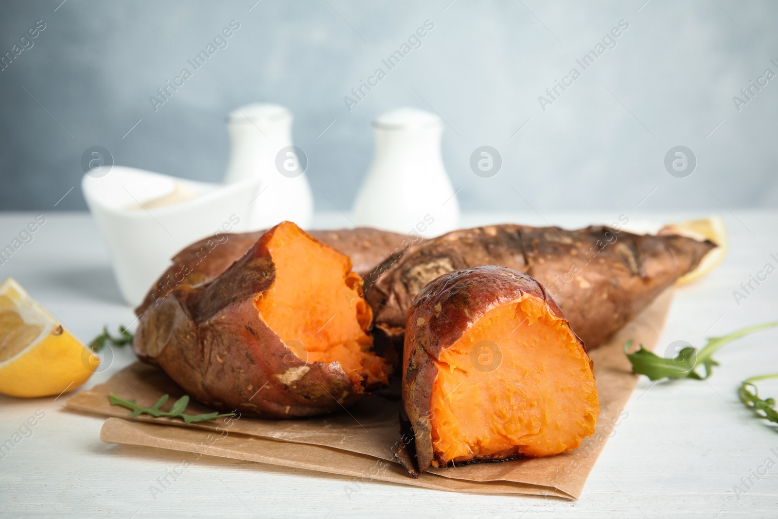 Photo of Delicious baked sweet potatoes on white table