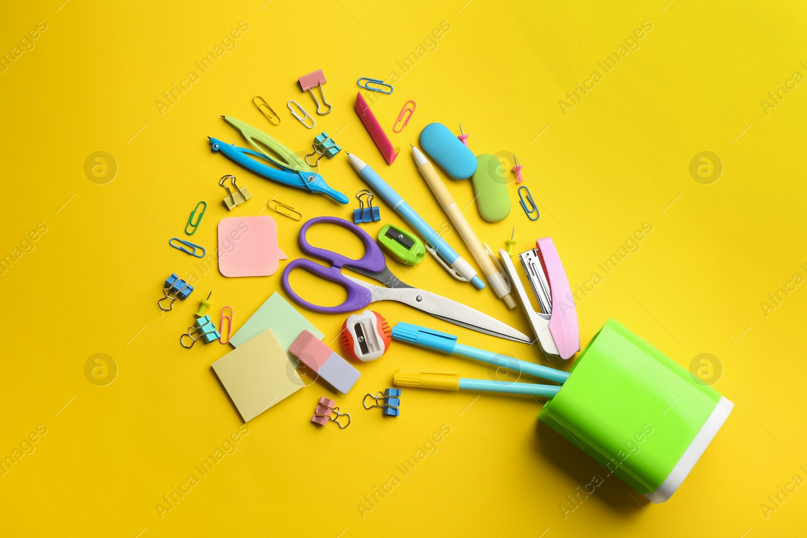 Photo of Flat lay composition with school stationery on yellow background. Back to school