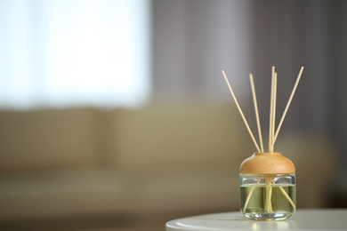 Aromatic reed air freshener on table indoors. Space for text