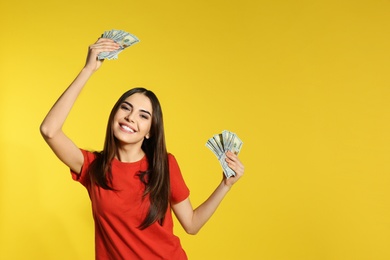 Young woman with money on color background. Space for text
