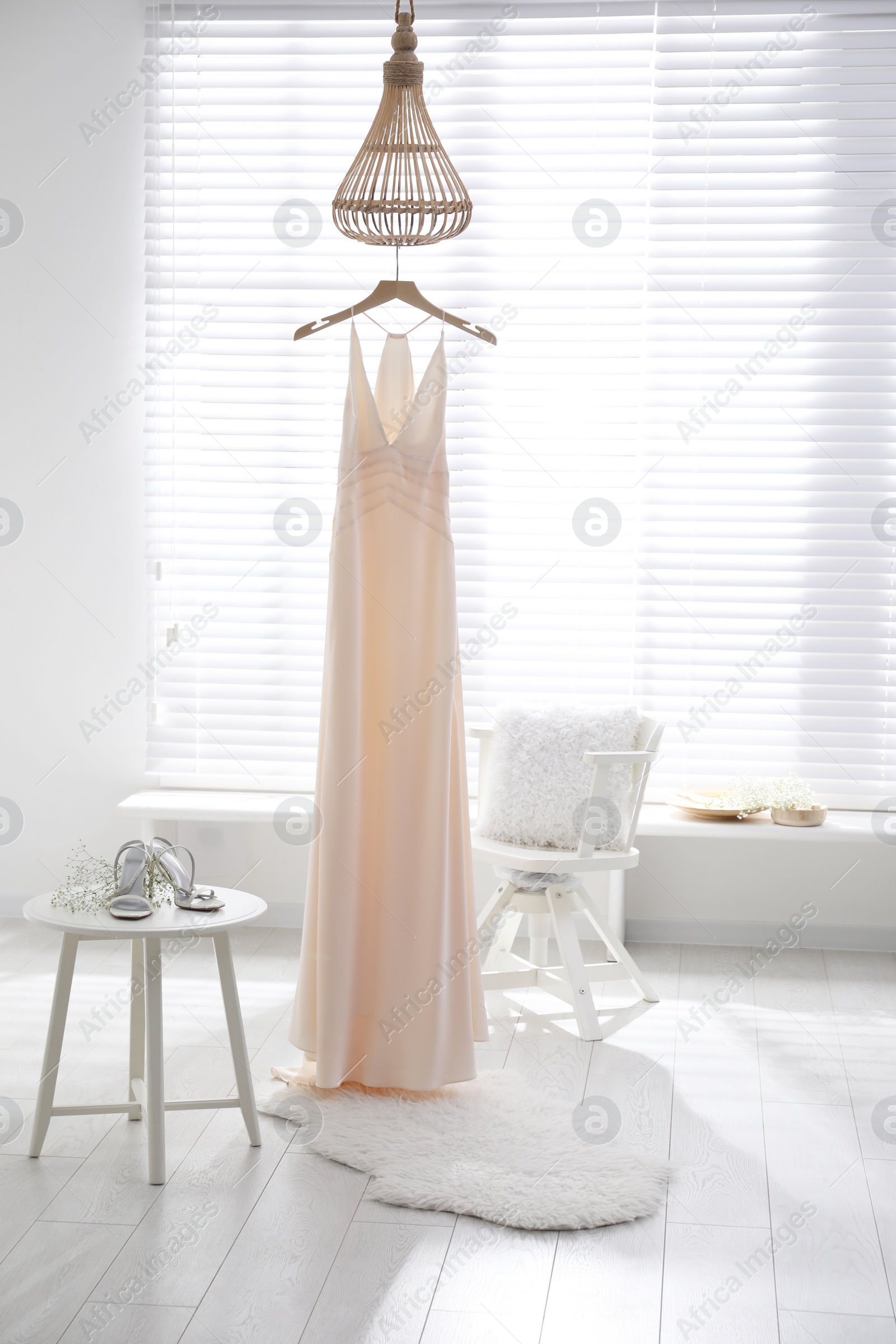 Photo of Beautiful wedding dress, shoes and flowers in room