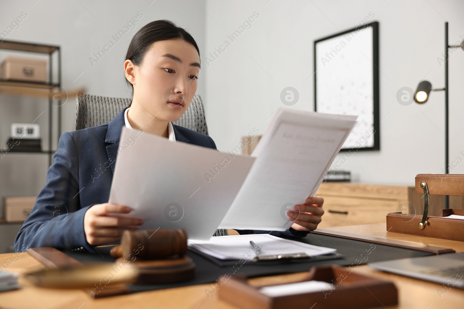 Photo of Notary reading documents at table in office