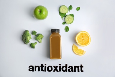 Flat lay composition with word ANTIOXIDANT, healthy detox smoothie and ingredients on light background