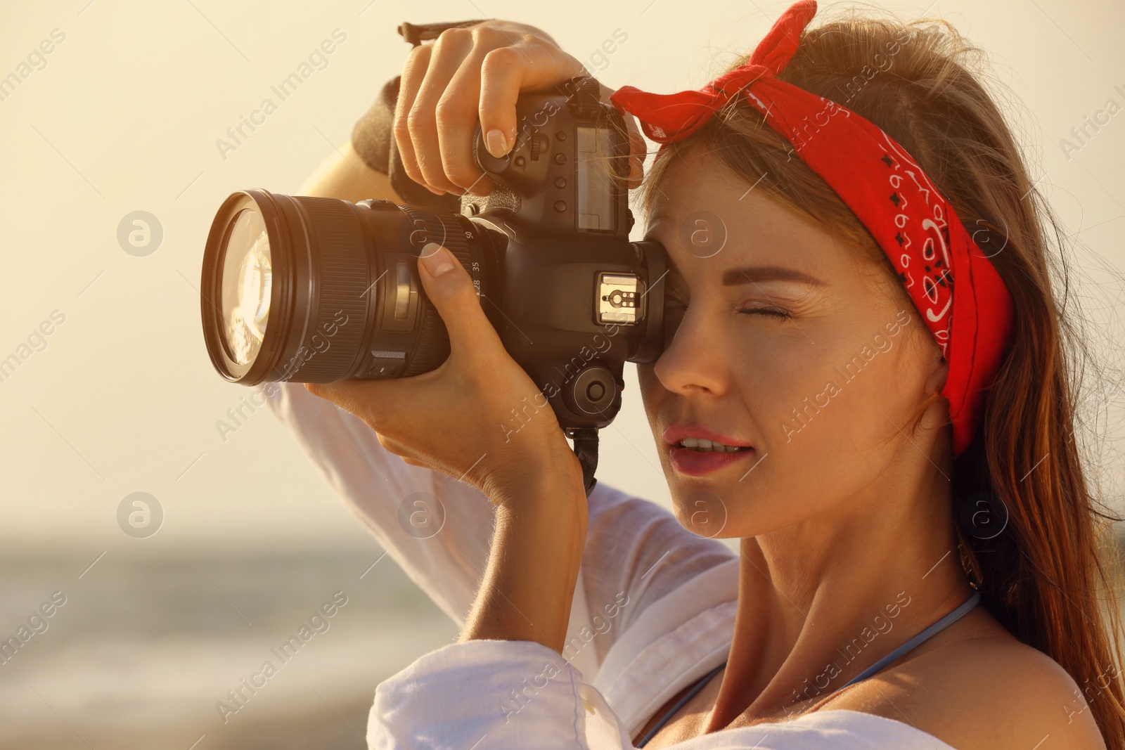 Photo of Photographer taking photo with professional camera outdoors