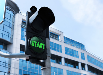 Image of New opportunities. Traffic light with green signal and word Start on city street