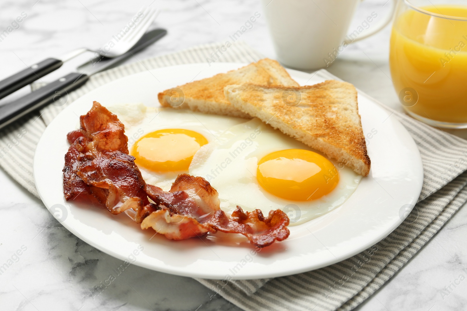 Photo of Delicious breakfast with sunny side up eggs served on white marble table, closeup