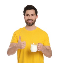 Photo of Handsome man with delicious yogurt showing thumb up on white background