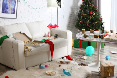 Photo of Messy living room interior with Christmas tree. Chaos after party