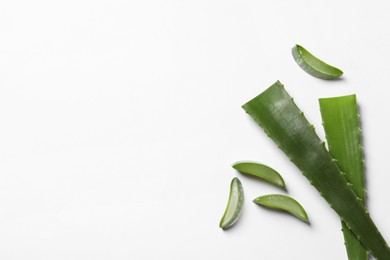 Cut aloe vera leaves on white background, flat lay. Space for text