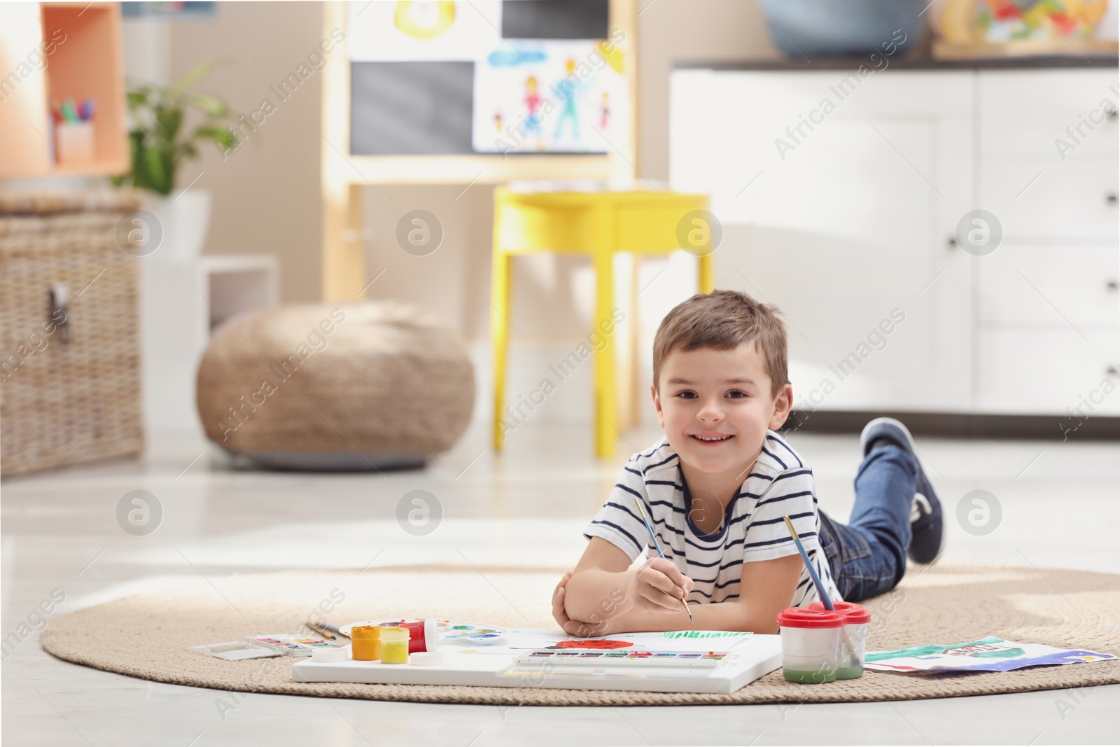 Photo of Little child painting on floor at home