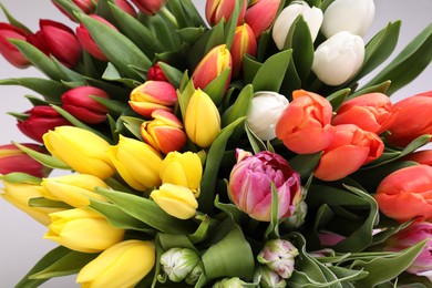 Photo of Beautiful colorful tulip flowers on light grey background, closeup with above view