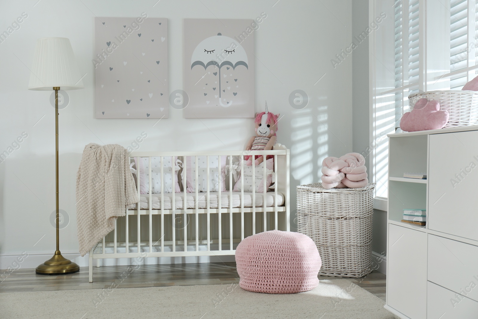 Photo of Stylish baby room interior with crib and cute pictures on wall