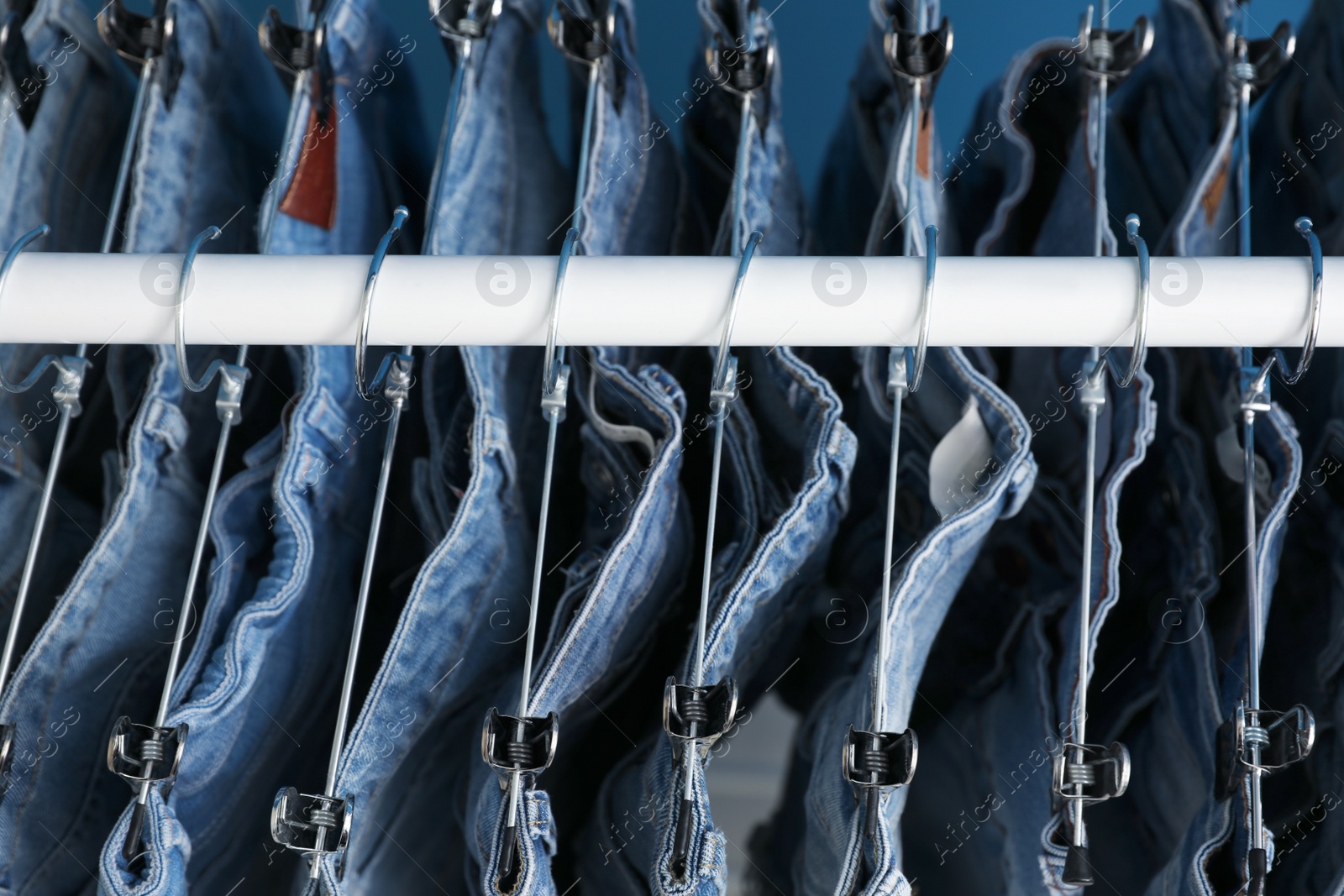 Photo of Hangers with stylish jeans on rack, above view