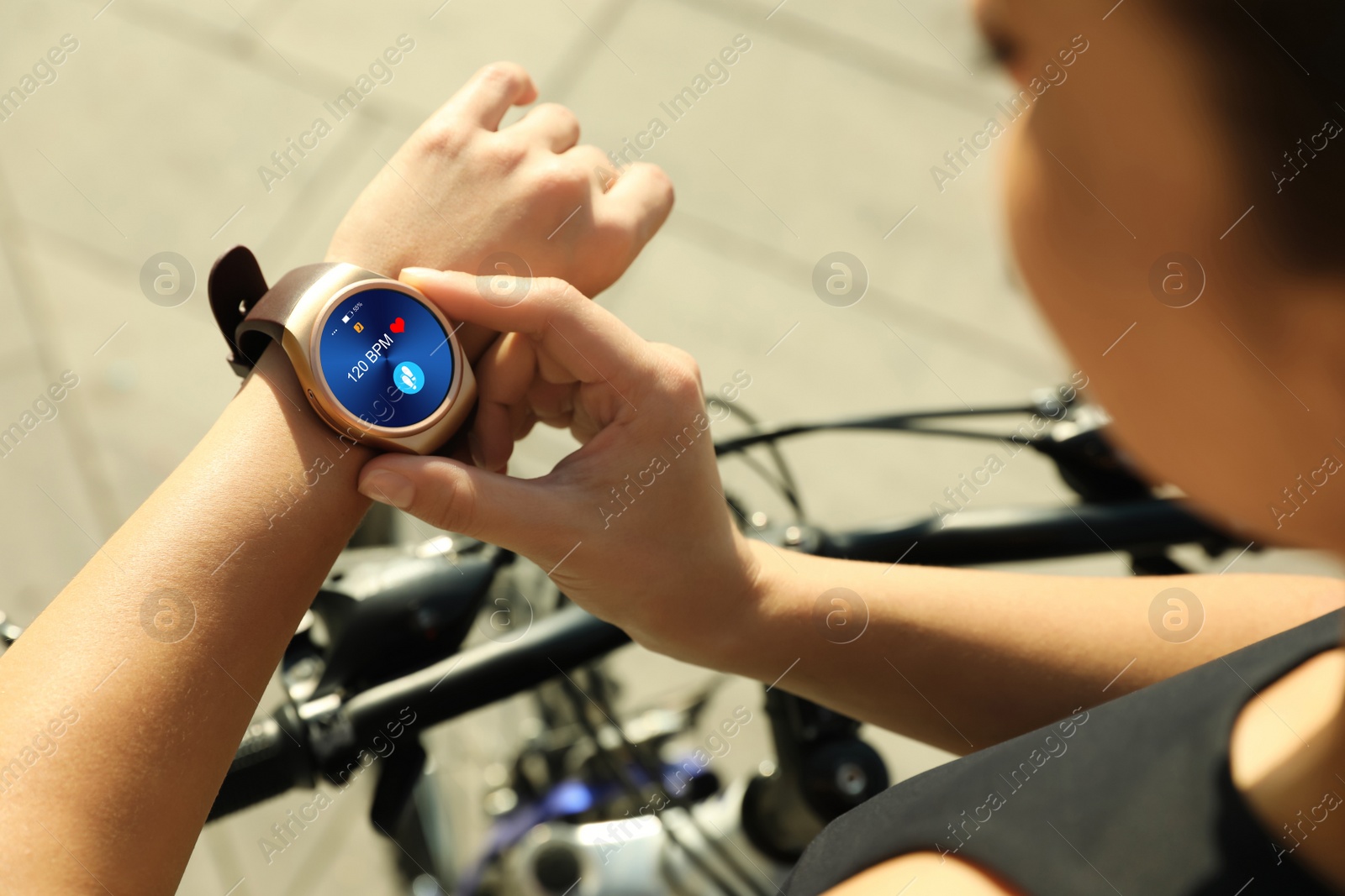 Image of Woman wearing modern smart watch during training outdoors, closeup