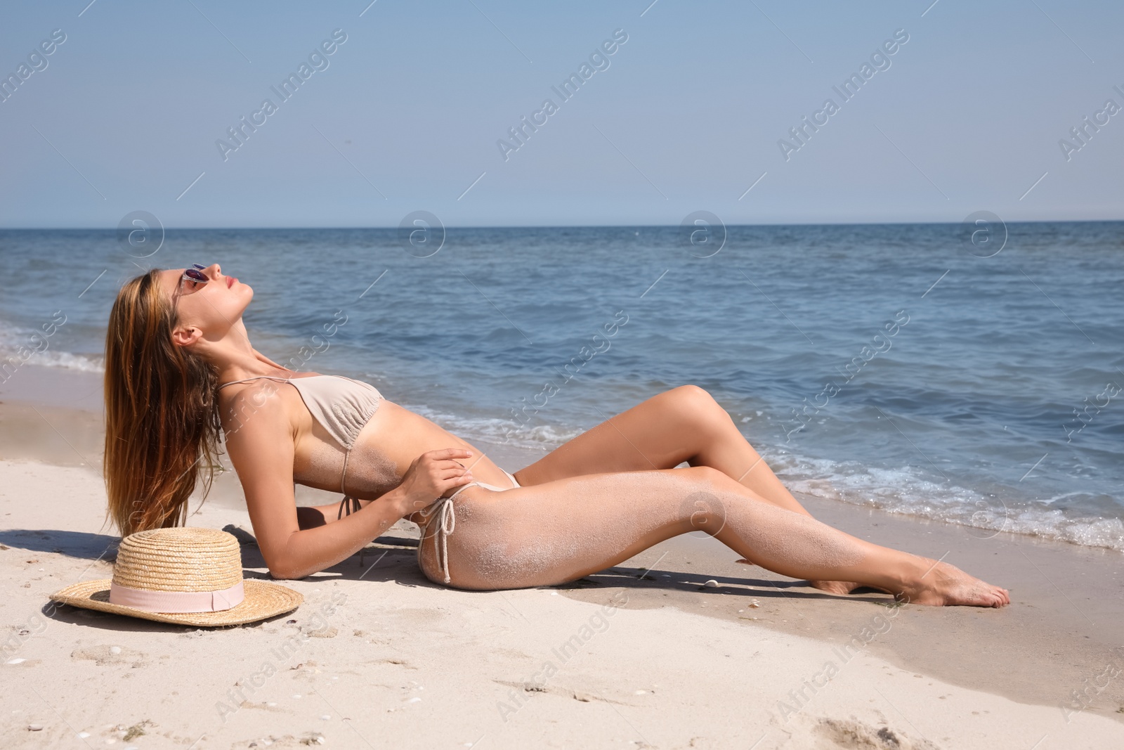 Photo of Attractive woman in bikini on sandy beach near sea