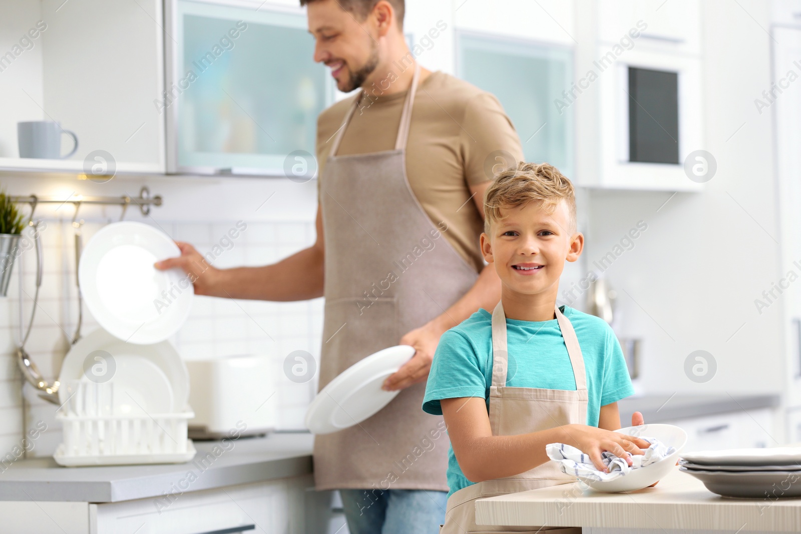 Photo of Dad and son wiping dishes in kitchen