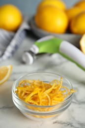 Photo of Lemon zest and fresh fruits on white marble table