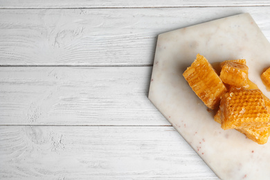 Fresh delicious honeycombs on white wooden table, top view. Space for text