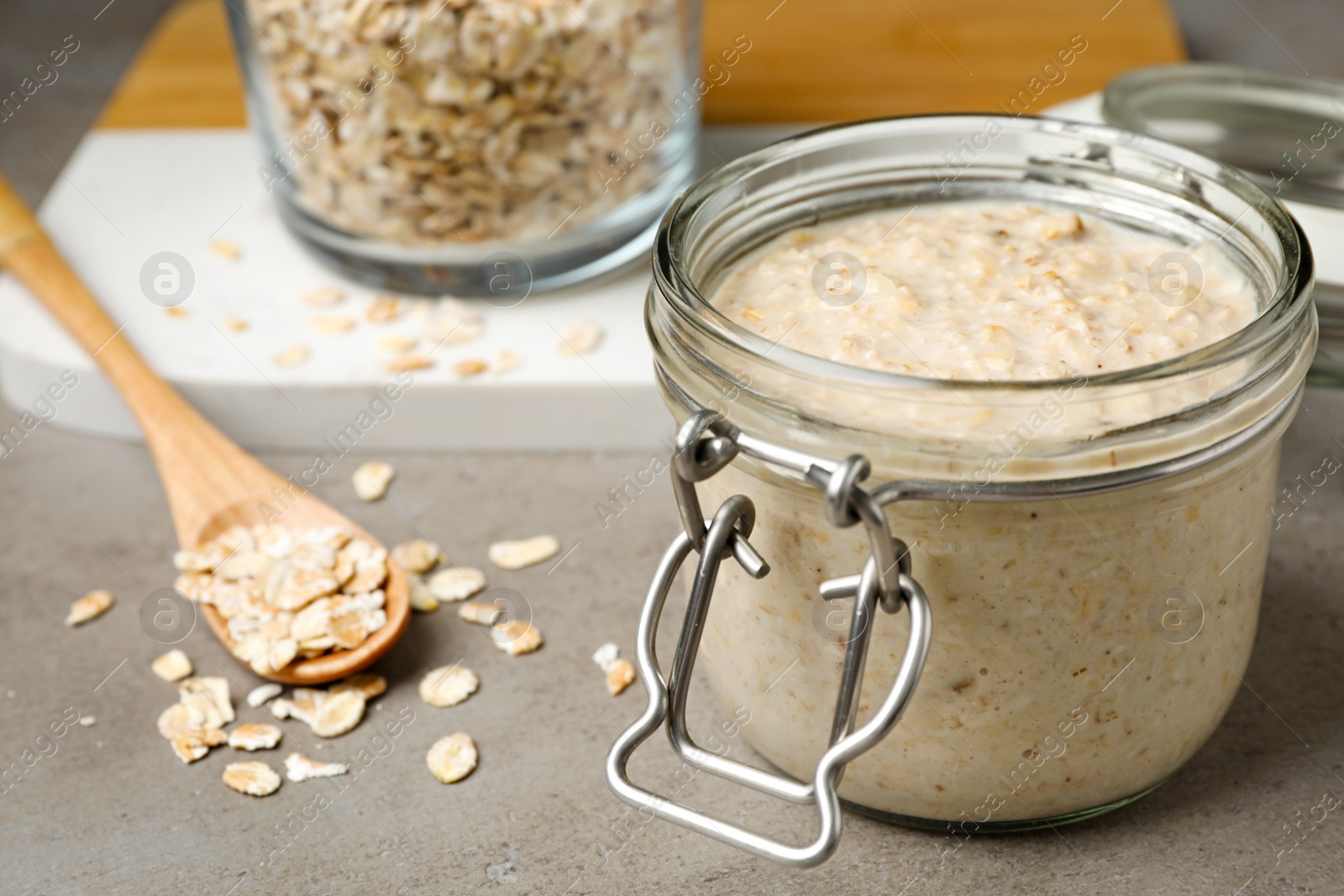 Photo of Handmade face mask and oatmeal on grey table