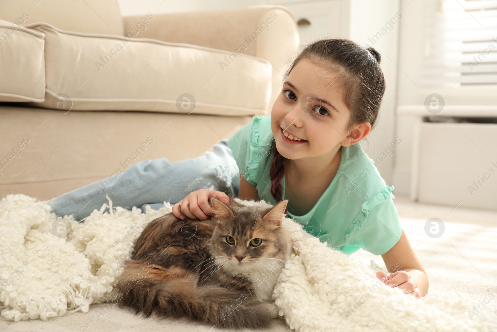 Photo of Cute little girl with cat lying on carpet at home. First pet