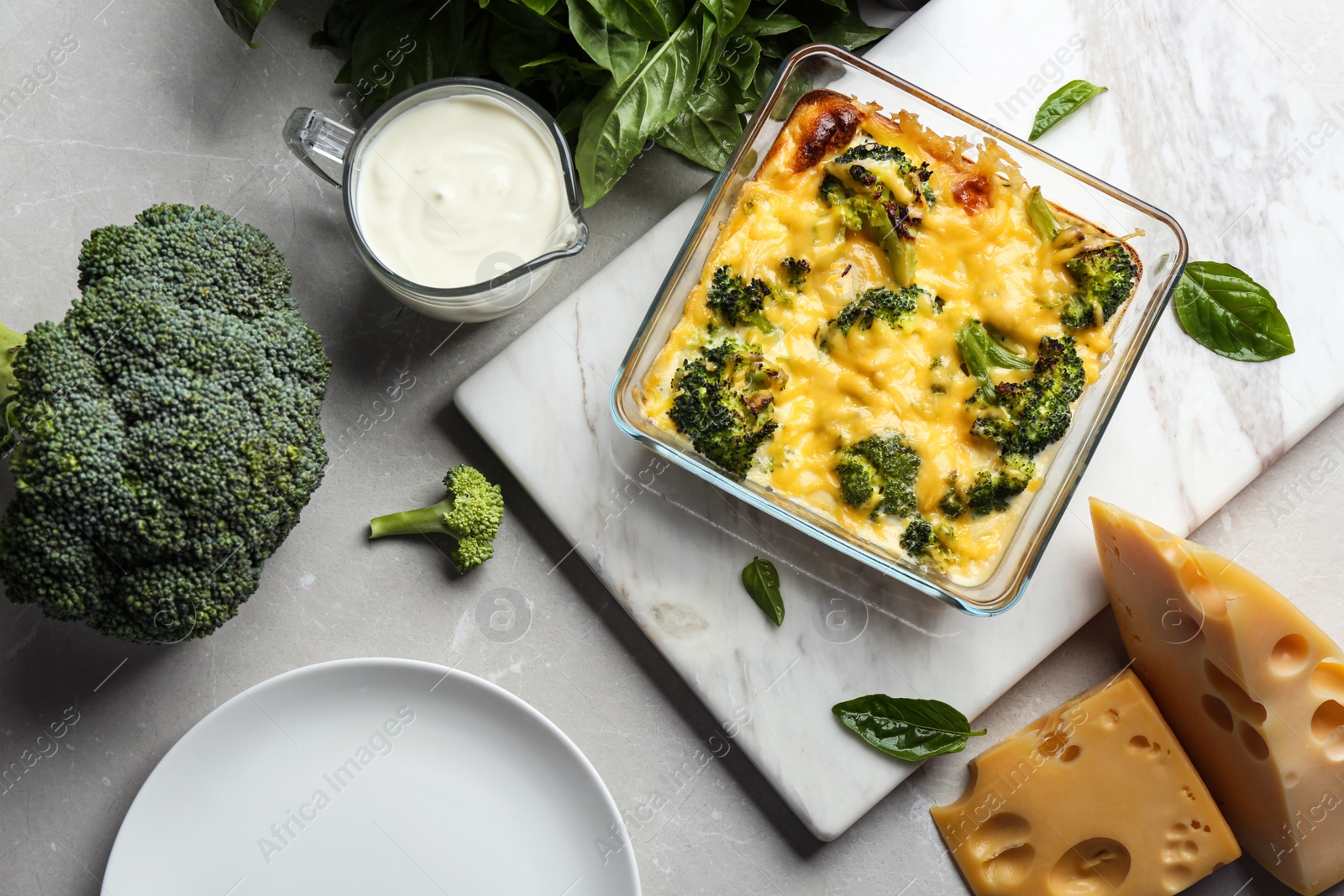 Photo of Flat lay composition with tasty broccoli casserole on grey marble table