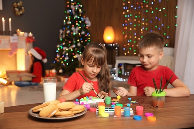 Little child decorating Christmas tree of foam plastic at home