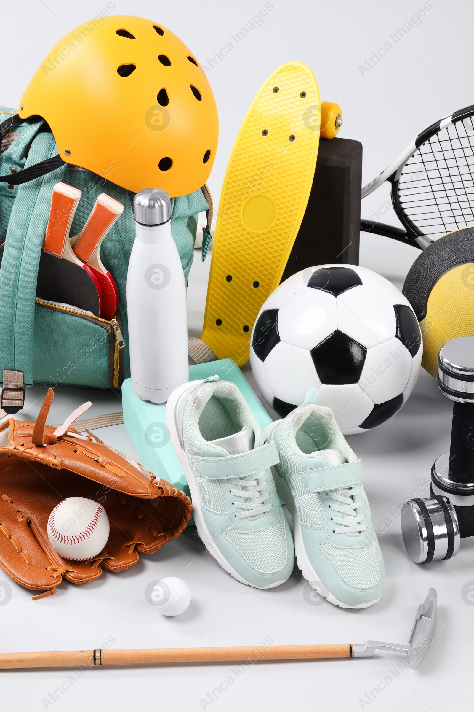 Photo of Many different sports equipment on light grey background