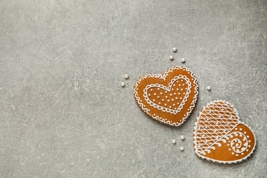 Photo of Tasty heart shaped gingerbread cookies on grey table, flat lay. Space for text