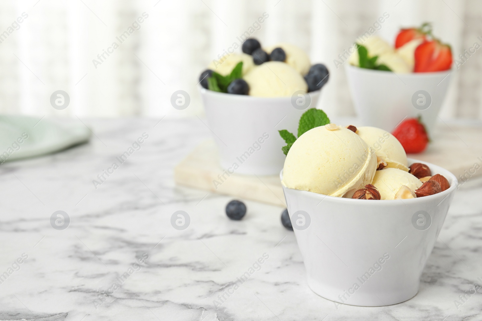 Photo of Delicious vanilla ice cream served on marble table. Space for text