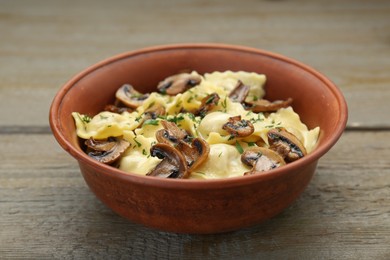 Delicious ravioli with mushrooms on wooden table, closeup