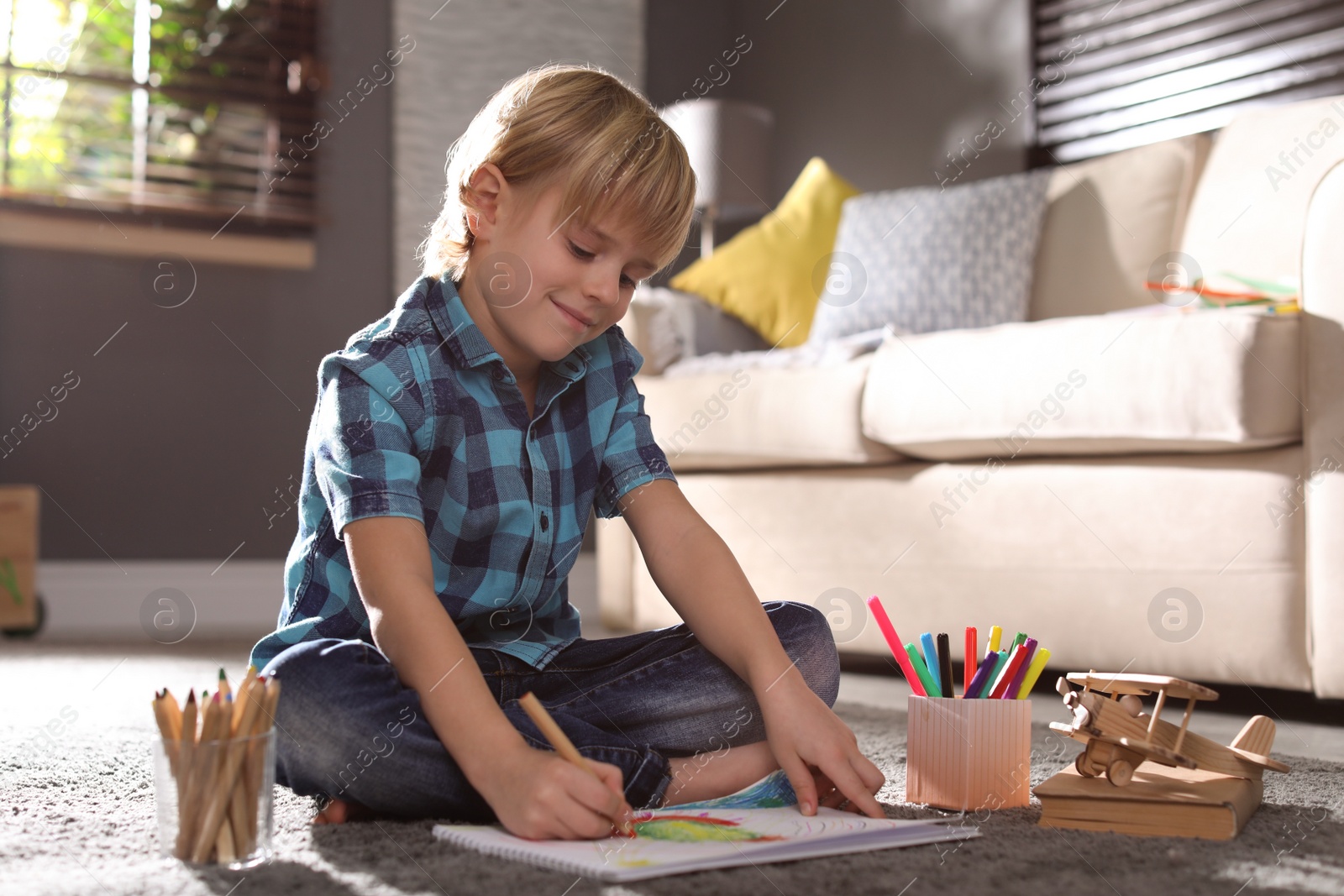 Photo of Little boy drawing on floor at home. Creative hobby