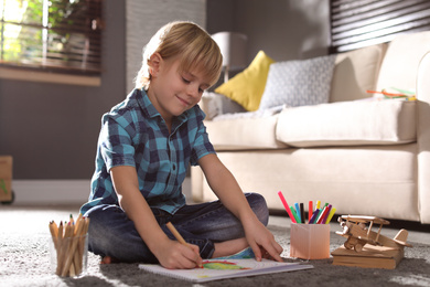 Photo of Little boy drawing on floor at home. Creative hobby