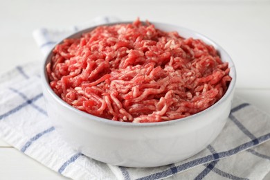 Photo of Raw ground meat in bowl on table, closeup