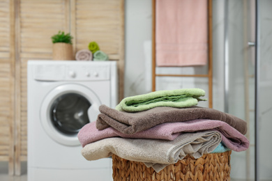 Wicker basket with laundry and washing machine in bathroom