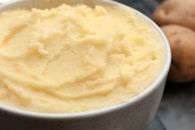 Photo of Tasty mashed potatoes served in bowl, closeup