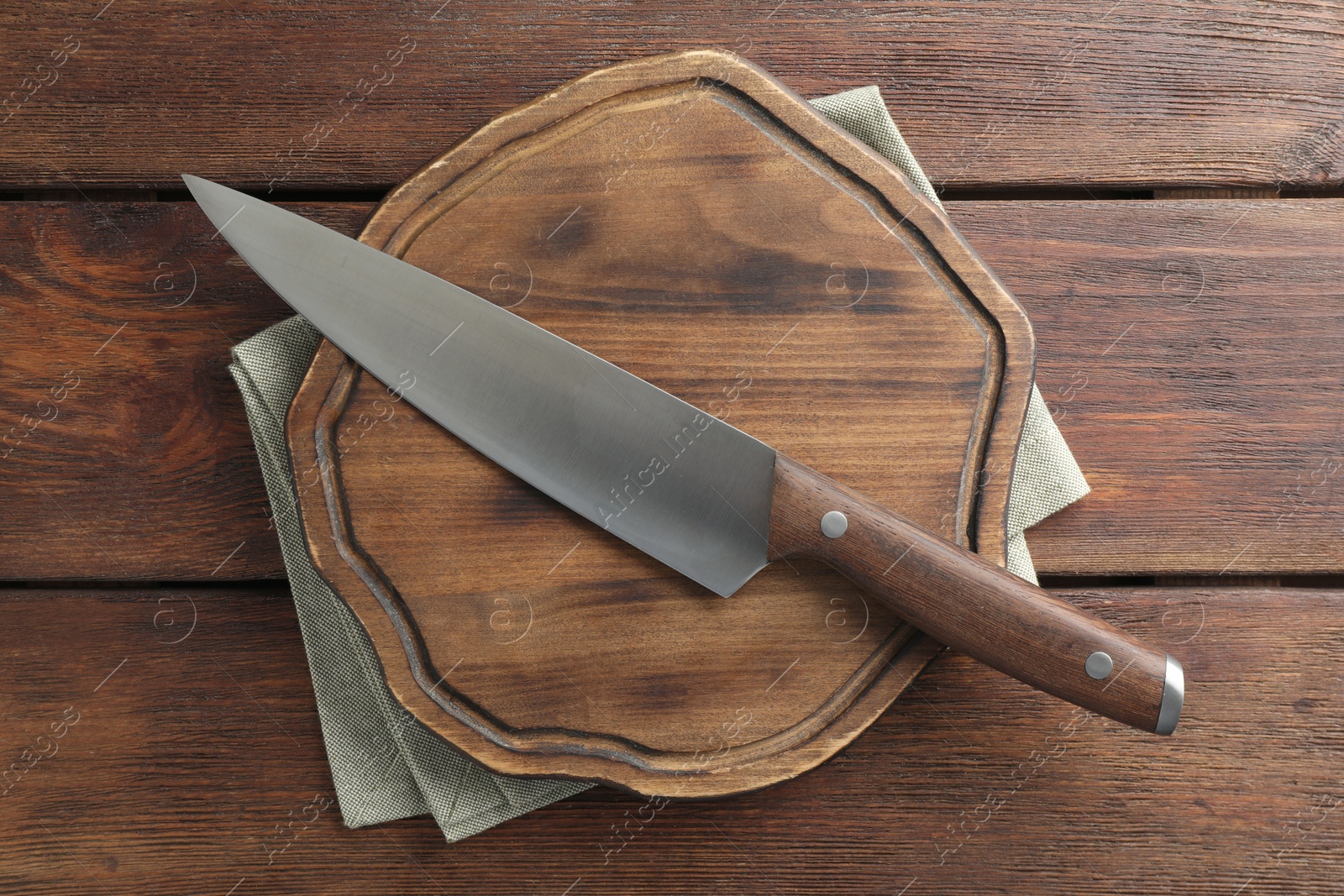 Photo of One sharp knife and board on wooden table, top view