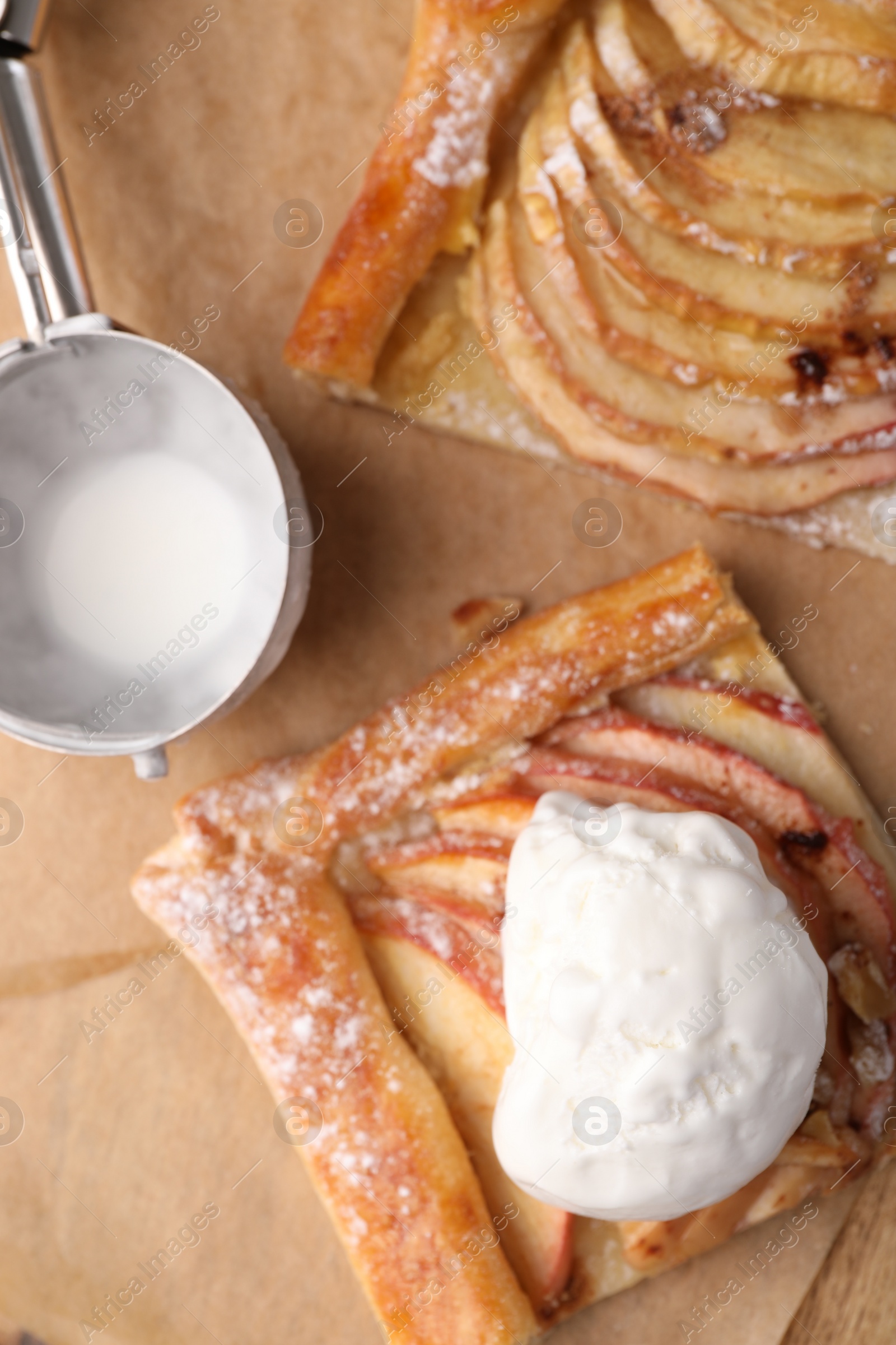 Photo of Pieces of freshly baked apple pie, ice cream and scoop on table, flat lay