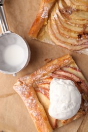 Pieces of freshly baked apple pie, ice cream and scoop on table, flat lay