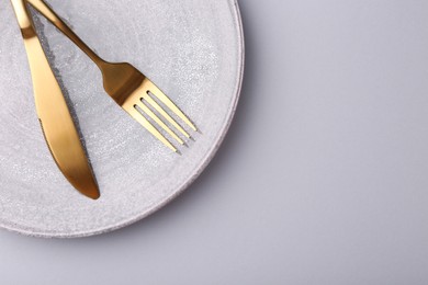 Setting with stylish cutlery on grey table, top view. Space for text