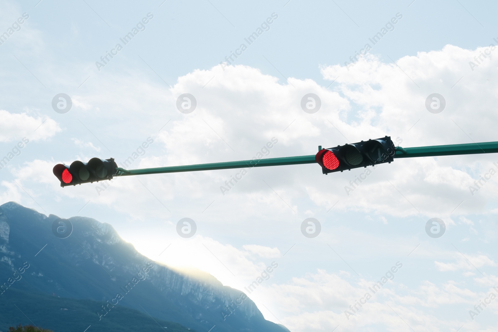 Photo of Traffic lights against blue sky outdoors. Road rules