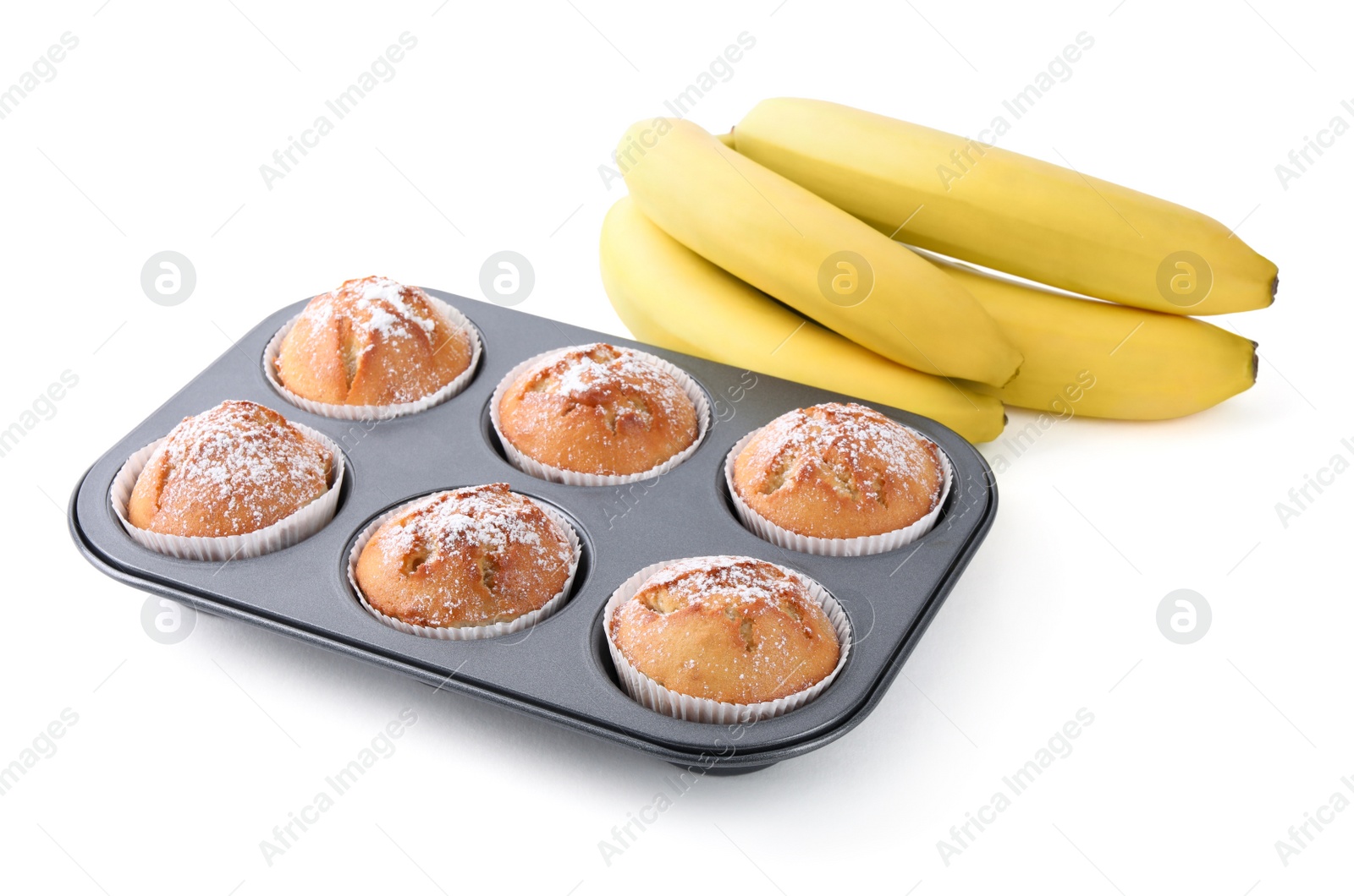 Photo of Ripe bananas and tasty homemade muffins powdered with sugar in tray on white background