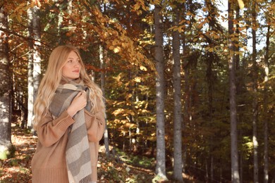 Portrait of beautiful young woman in autumn forest. Space for text