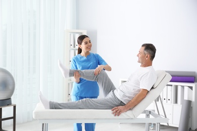 Photo of Doctor working with patient in hospital. Rehabilitation physiotherapy