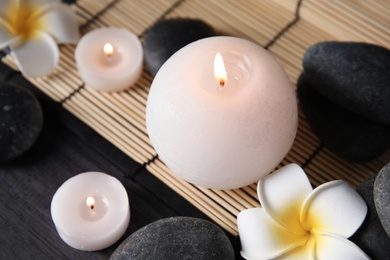 Photo of Spa stones, candles and flowers on table, closeup