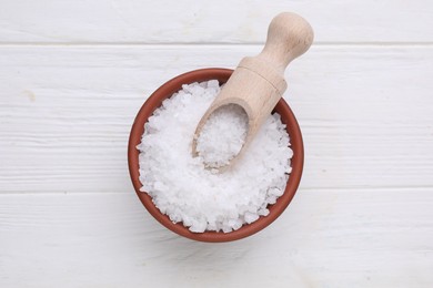 Photo of Bowl and scoop with sea salt on white wooden table, top view