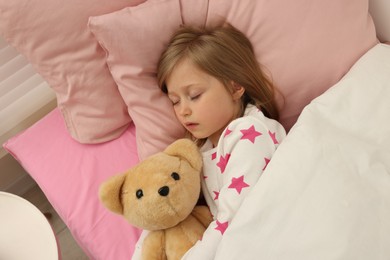 Photo of Little girl snoring while sleeping in bed, above view