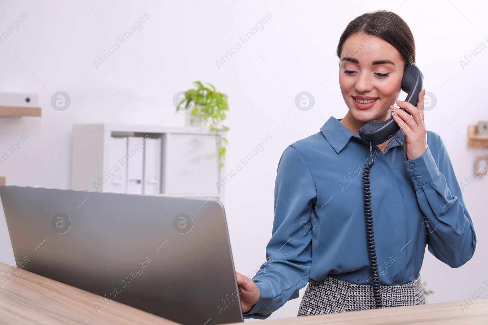 Photo of Female receptionist talking on phone at workplace