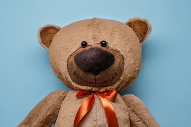 Cute teddy bear on light blue background, top view