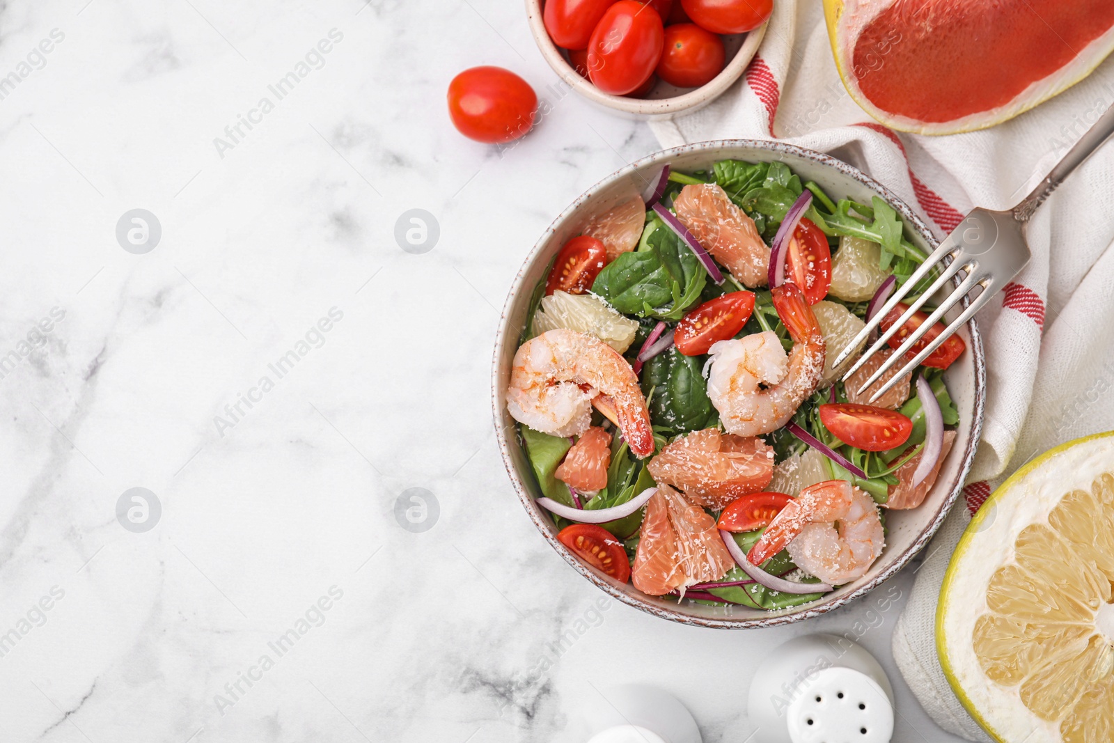 Photo of Delicious pomelo salad with shrimps served on white marble table, flat lay. Space for text