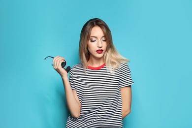 Photo of Beautiful young woman with healthy long blonde hair on color background